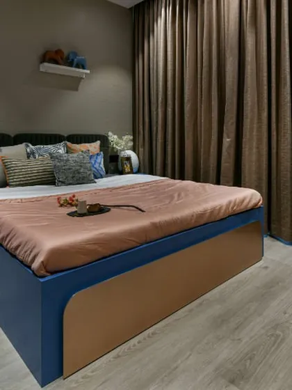 I designed this guest room with a mix of cool and warm tones to be both inviting and stylish. The classic blue wardrobe, shimmering champagne wallpaper, and warm wooden floor create a modern twist on classic design.