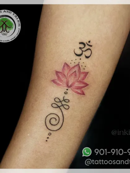 A Unalome tattoo combined with a pink lotus and Om symbol. The soft color in the lotus adds a beautiful touch to this spiritual design.