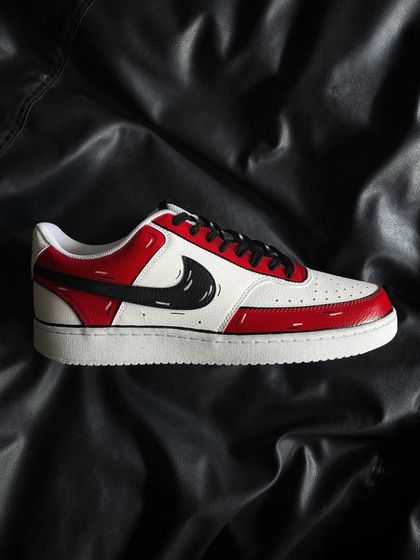 A side profile of the red cartoon custom sneaker on a black background.