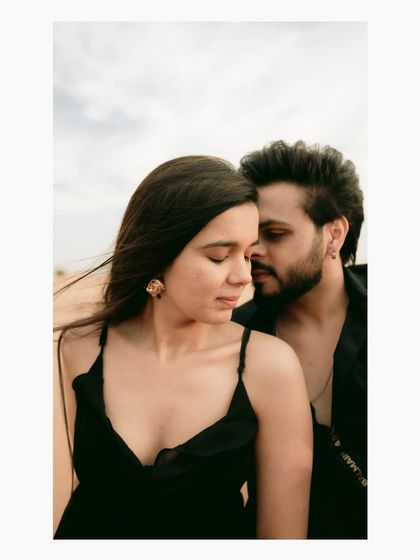 A tender, close-up portrait of a couple in the desert. The focus is on their quiet connection and the soft, natural light that highlights their features.