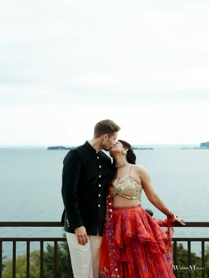 A romantic kiss between the couple, set against the serene backdrop of Lake Garda, Italy. This photograph captures an intimate moment while showcasing the stunning scenery of a destination wedding, blending love with wanderlust.