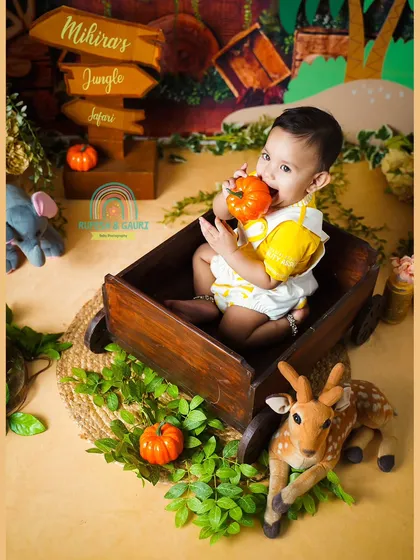 A cute moment from a jungle safari themed shoot, where the birthday girl decided the pumpkin prop looked delicious.