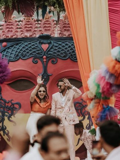 A wide shot of the couple making their entrance, capturing the scale and energy of the carnival party.
