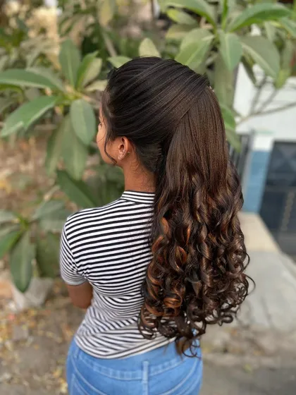 A simpler but equally beautiful version of a curly ponytail. This style is perfect for a party or pre-wedding event, offering a chic and polished look.