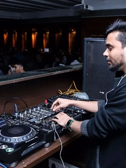 A focused moment behind the decks, ensuring the sound is perfect for the room. I use professional Pioneer DJ equipment for all my gigs.