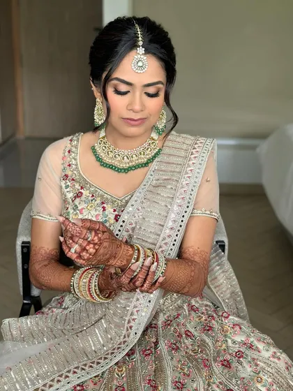 A quiet moment before the ceremony. The soft glam makeup looks flawless, with flushed lids and a luminous base that will last from 'I do' to the final dance.