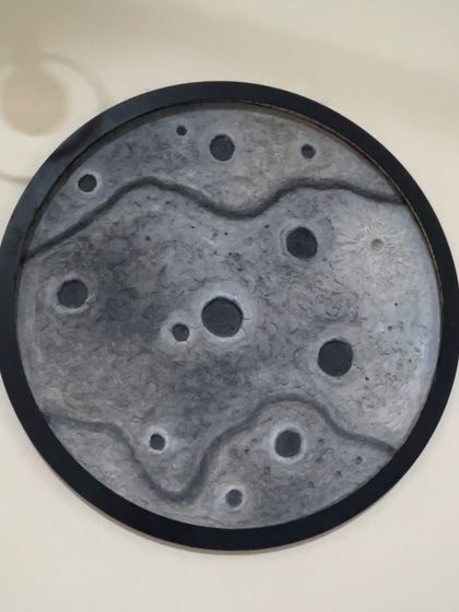 A different design for the moon lamp, this one with a black frame and a more subtle, wavy texture across the surface.