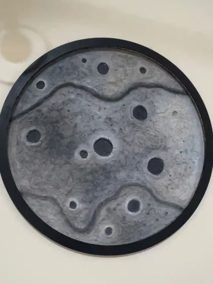 A different design for the moon lamp, this one with a black frame and a more subtle, wavy texture across the surface.