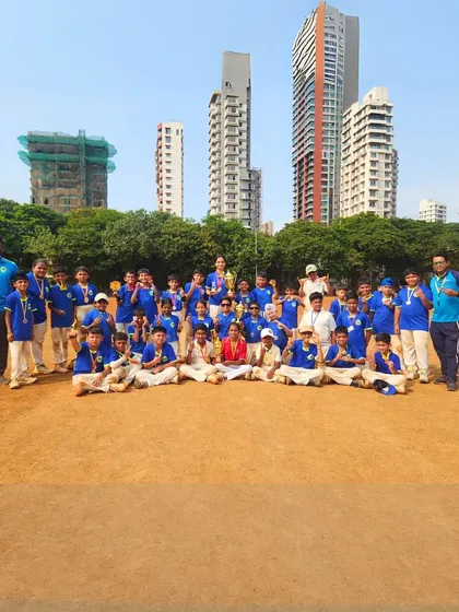 A full squad photo of one of our champion teams, celebrating with medals on the field against a city skyline, showing the urban environment of our training grounds.