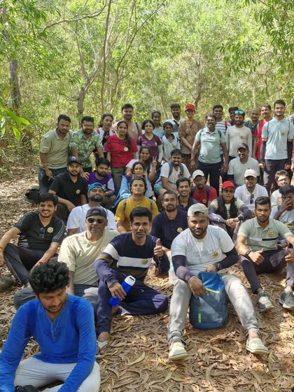 The whole group taking a break in a shaded forest area along the coastal trail.