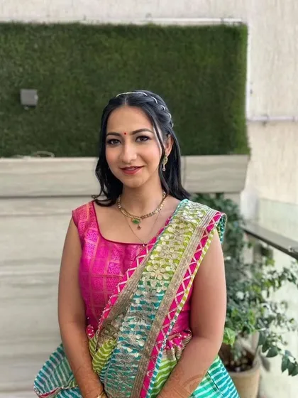A simple and elegant look for a pre-wedding event. The bride's colorful saree is paired with a minimal makeup look and a braided hairstyle.