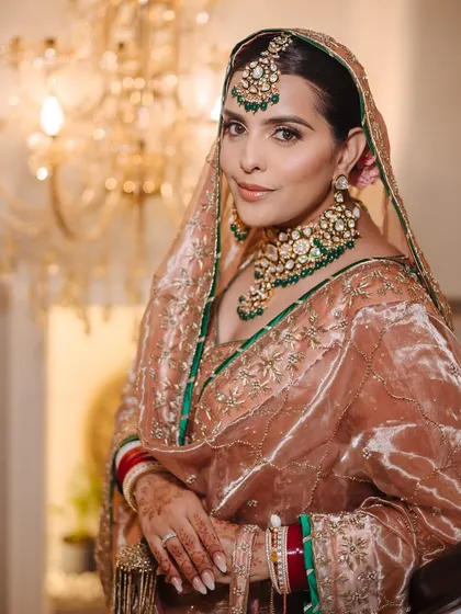 A classic portrait of a Sikh bride, looking directly at the camera with a gentle smile.