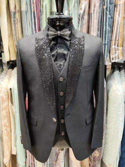 A full view of the black three piece suit with sequined lapels, displayed in our studio. This outfit combines classic tailoring with a touch of glamour.