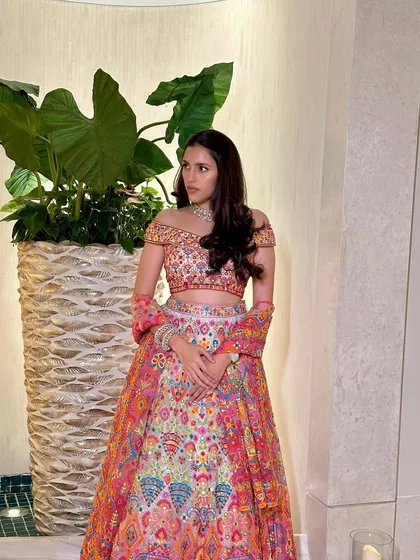 A full look at this stunning multi-colored Abu Jani Sandeep Khosla lehenga. The off-shoulder blouse and vibrant skirt make it a perfect choice for a sangeet or reception.