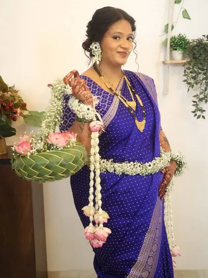 Here is a lovely client wearing a floral set with a matching coconut leaf basket. The jewellery combines delicate white buds with pink lotus accents, perfectly coordinating with the flowers in the basket.