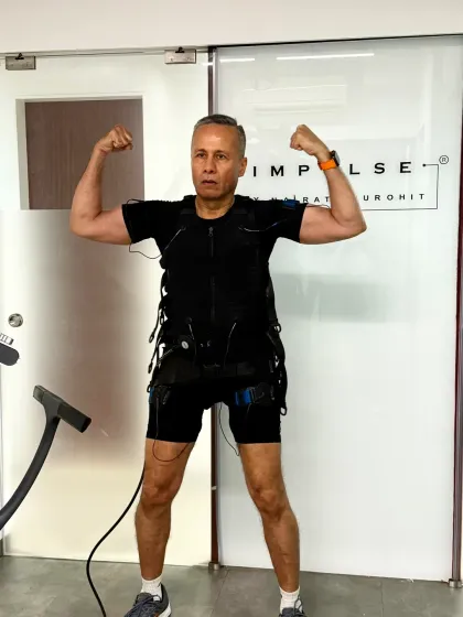 A client shows off his strength post workout. EMS helps build lean muscle for a more toned and powerful physique.