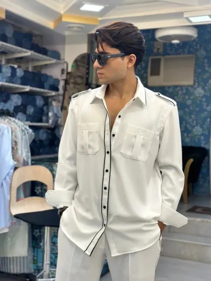 A full look at the white co-ord set with black piping. The relaxed fit and sharp detailing make it a versatile outfit for various occasions, from a brunch to a casual evening out.