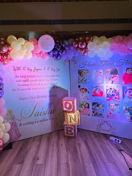 A personalized storybook backdrop for a princess themed party, featuring a photo collage of the birthday girl's first year.