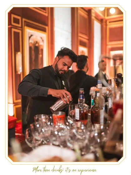 A bartender in his element, focused on the pour. This photo, taken at an elegant event, captures the concentration and professionalism our team brings to every single drink they make.