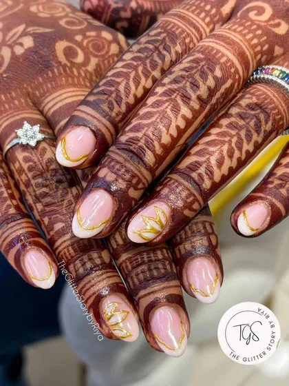 Simple elegance for the modern bride. These nails feature a clean, sheer base with delicate gold leaf patterns painted on the tips, designed to beautifully complement the henna.