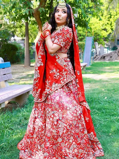 A full-length view of the classic red bridal lehenga, showcasing its beautiful flare in an outdoor setting.