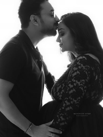 A tender black and white close-up of a husband kissing his wife's forehead. This classic pose is a beautiful expression of love and care.