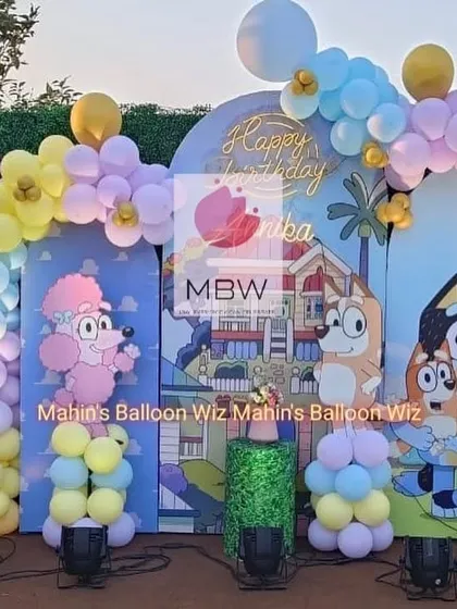 A fun and playful Bluey-themed birthday party. The outdoor setup includes a custom backdrop with characters from the show and a cheerful pastel balloon arch.