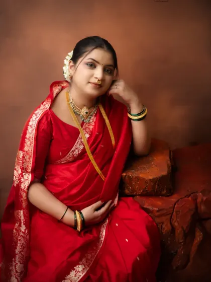 A portrait of quiet confidence and grace. The rich red saree and traditional jewelry create a powerful and timeless look, celebrating the beauty of motherhood.