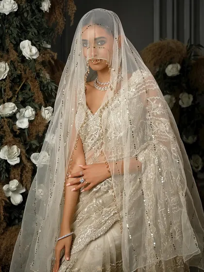 The mystery and allure of a bride under a veil. This shot highlights the delicate sequin work on the dupatta and the overall dreamy quality of the styling.