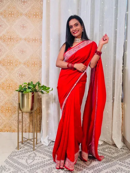 A classic red georgette saree with a simple, elegant border. This is a timeless piece that you can wear for Karva Chauth, Diwali, or any wedding.