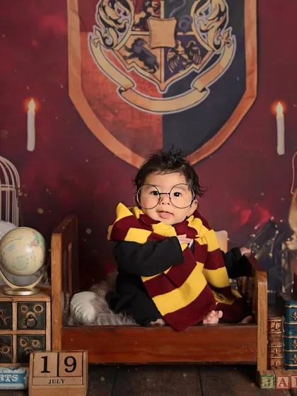 Wingardium Leviosa! We can bring a little magic to your baby's photoshoot with a fun theme like this Harry Potter setup. It's all about capturing their budding personality in a creative way.