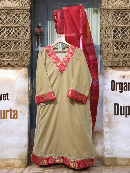 Ethnic simplicity at its finest. This beige velvet kurta features a beautiful pink embroidered border and is paired with a lightweight organza dupatta for a graceful look.