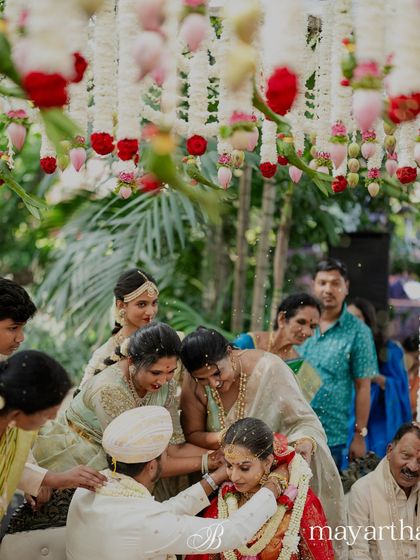 Family members gather to bless the couple under a canopy of flowers. The decor is intentionally kept light and airy to complement the outdoor setting and the morning light.