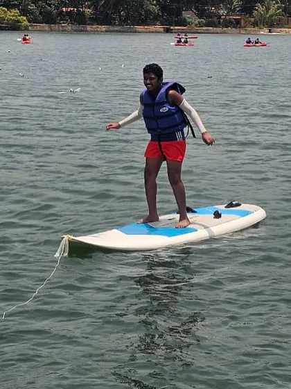 A participant practices balancing on a stand-up paddleboard at our Karwar camp, a foundational skill for many water sports.