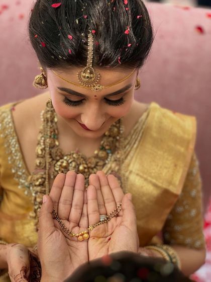 A precious moment as the groom presents the mangalsutra. This close-up highlights the bride's soft, glowing makeup and the emotion of the South Indian wedding ceremony.