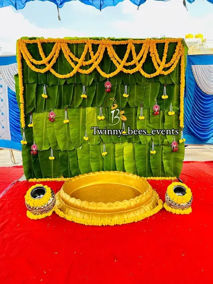 For a truly authentic Haldi ceremony, we use traditional elements like a backdrop of fresh banana leaves, garlands of bright yellow marigolds, and a central brass Urli for the rituals.