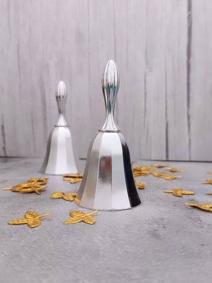 A pair of decorative German silver bells. The sound of the pooja bell is believed to ward off negative energy and invoke divinity.