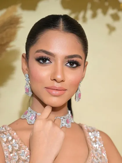 A close-up on the makeup for this brown skin beauty. The focus is on a flawless, sculpted base and a dramatic, sharp-winged eyeliner.