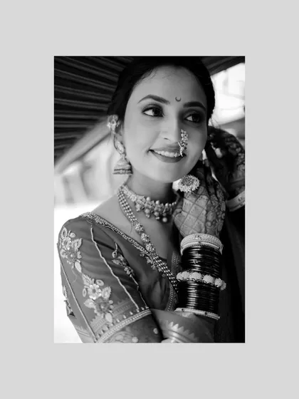 A timeless black and white portrait of the bride, her smile and traditional jewelry shining through.