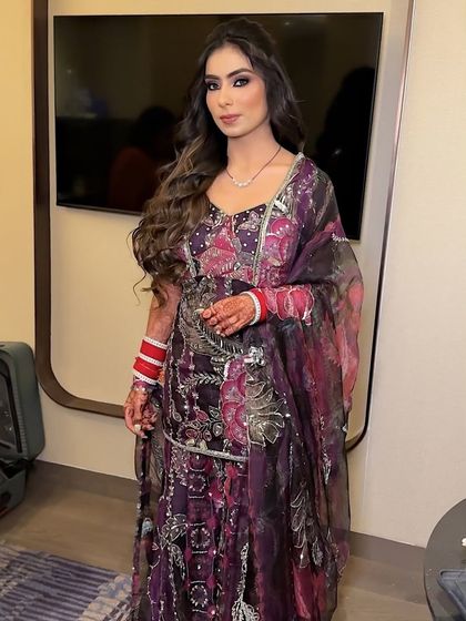A full-length shot showing how the makeup complements the intricate purple and silver outfit. The glamorous makeup completes this perfect party look.