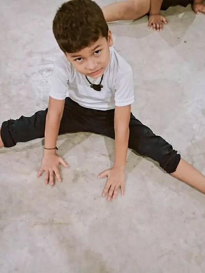 Winners are not born, they are made through hard work. This young student is working on his flexibility with a straddle stretch.