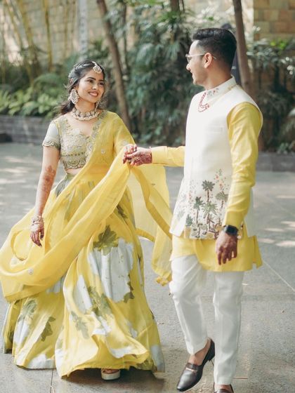 Another lovely shot of the couple enjoying their Haldi day. The bride's hair is styled in loose waves, adding to the romantic and carefree feel of the look.
