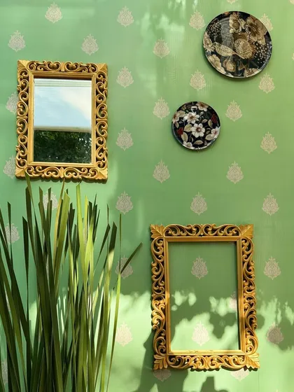 Details on the wall: ornate gold frames and decorative plates add texture and an antique feel to the backdrop.