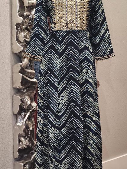 A beautiful indigo anarkali-style dress with a chevron print. The yoke is heavily embellished with intricate beadwork, adding a touch of glamour.