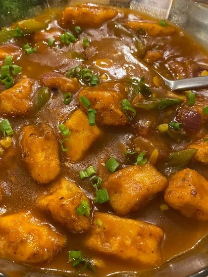 A comforting bowl of Tofu in Hot Garlic Sauce. Soft chunks of tofu are simmered in a rich, flavourful gravy with bell peppers and onions, making for a delicious main course.