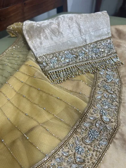 Tassels and crystals! A close-up of a heavily embellished blouse with intricate crystal, bead, and bugle bead tassels.