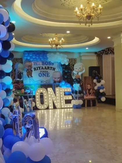 A wide view of a banquet hall decorated for a Boss Baby 'Turns One' party.