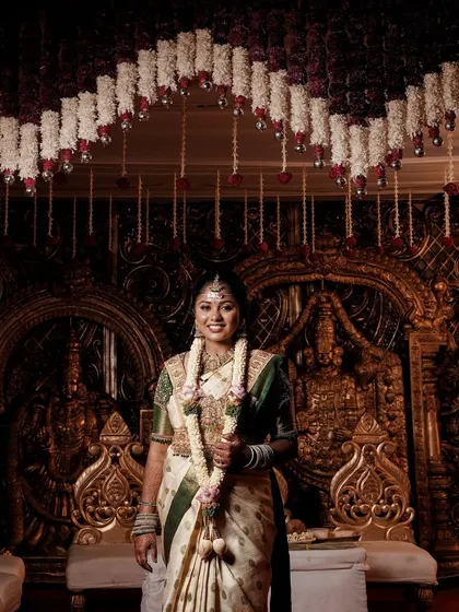 This bride is all smiles at her wedding. The grand temple-style backdrop is perfectly complemented by her traditional attire and the classic, elegant makeup I created for her.