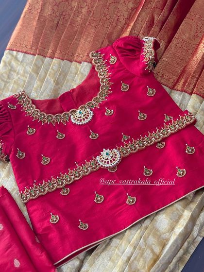 The front view of the red kids' blouse, adorned with delicate butti work and a jewellery-inspired neckline and waist belt.