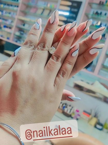 A minimalist and modern design with abstract black and white lines on long stiletto nails. This look proves that simple lines can create a very chic and artistic effect.